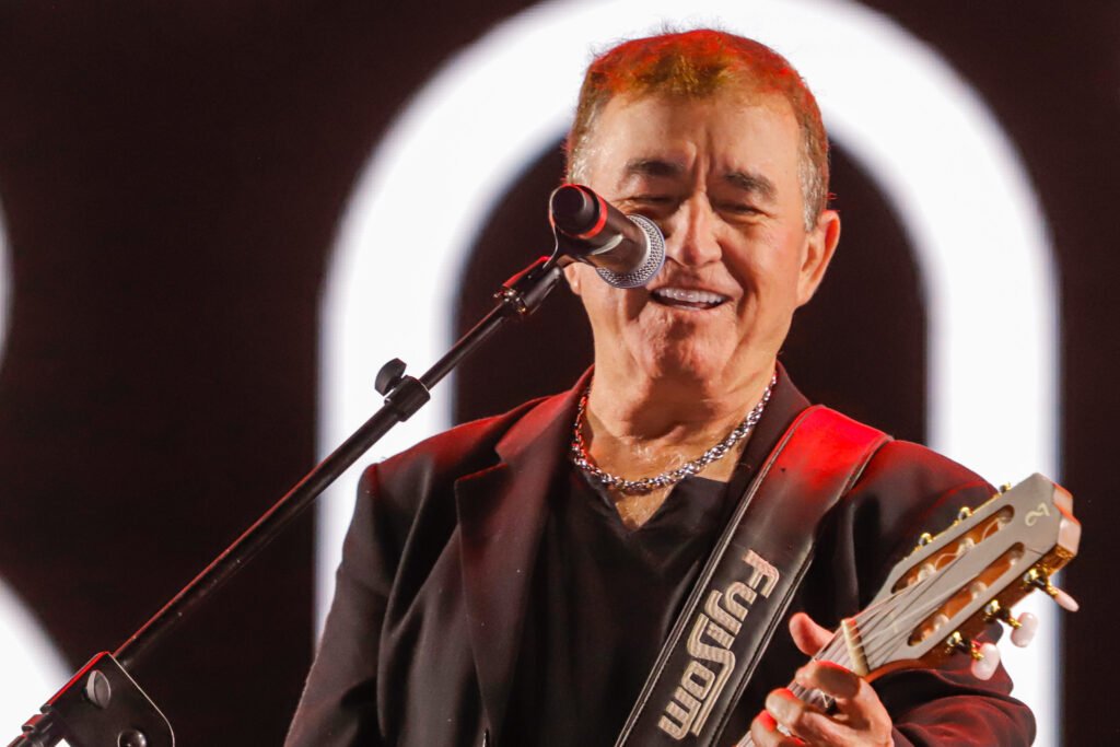 Amado Batista canta e toca violão durante show, em fotografia de apresentação anterior
