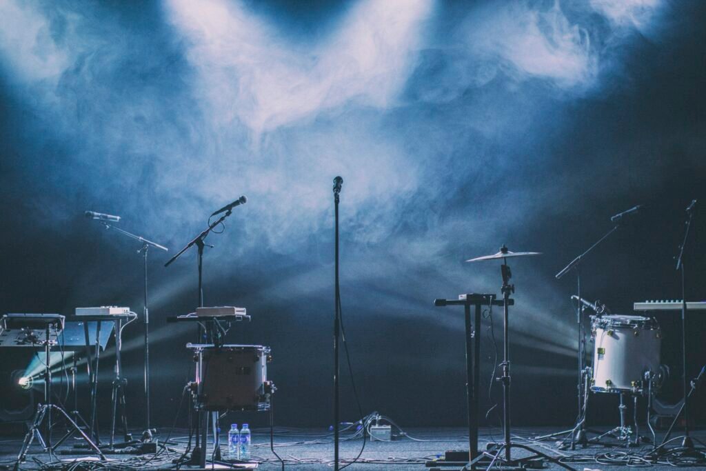 Bloco do Eu Sozinho em Goiânia: palco de rock com bateria, teclado e microfones sob luz azul e fumaça