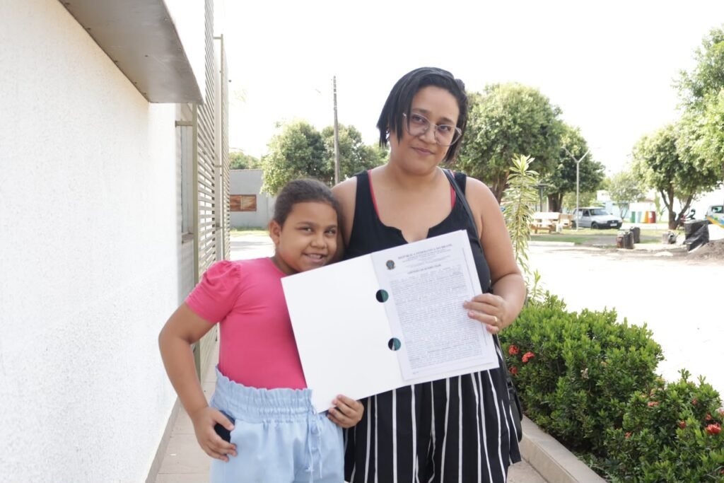 Mãe e filha mostram a escritura da casa recebida pelo programa Casas a Custo Zero