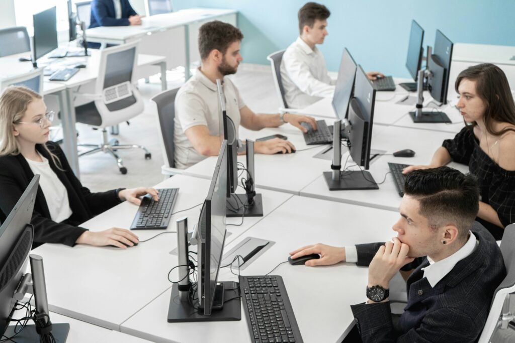 Jovens trabalhando em computadores em uma sala de inovação