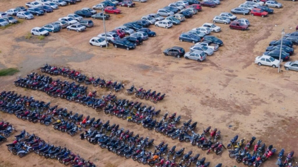 Vista aérea do pátio do Detran-GO com fileiras de carros e motos que vão a leilão em novembro