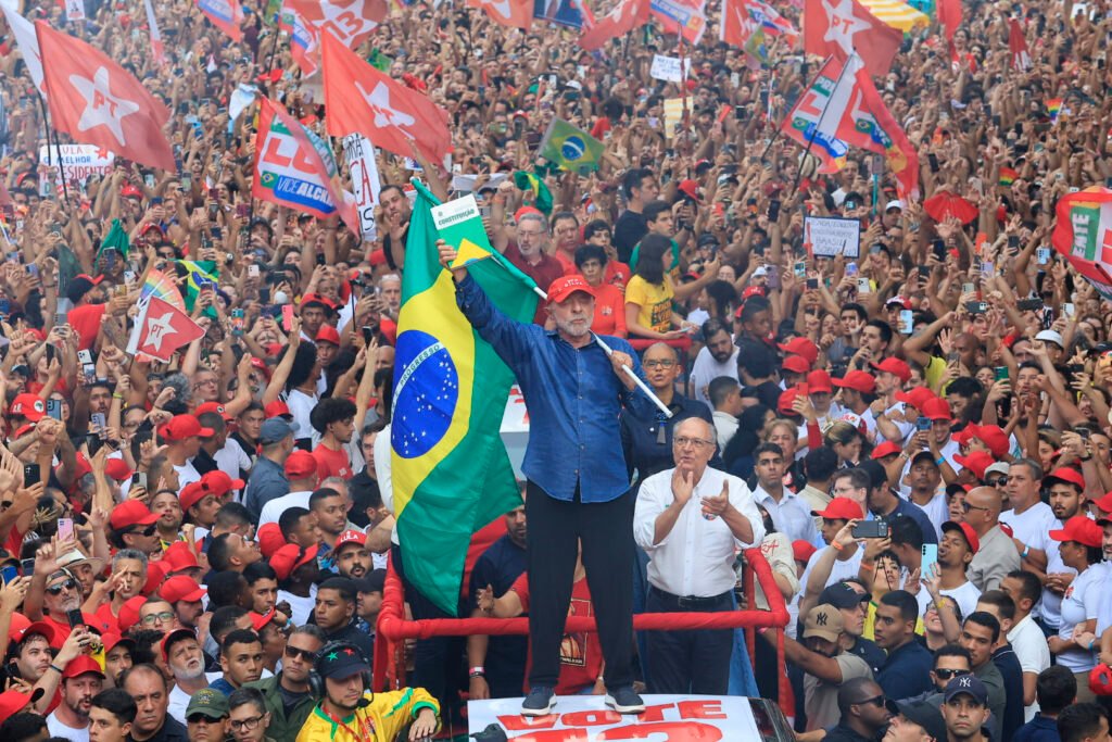 Lula acena para apoiadores com a bandeira do Brasil; petista é reeleito presidente pela quarta vez